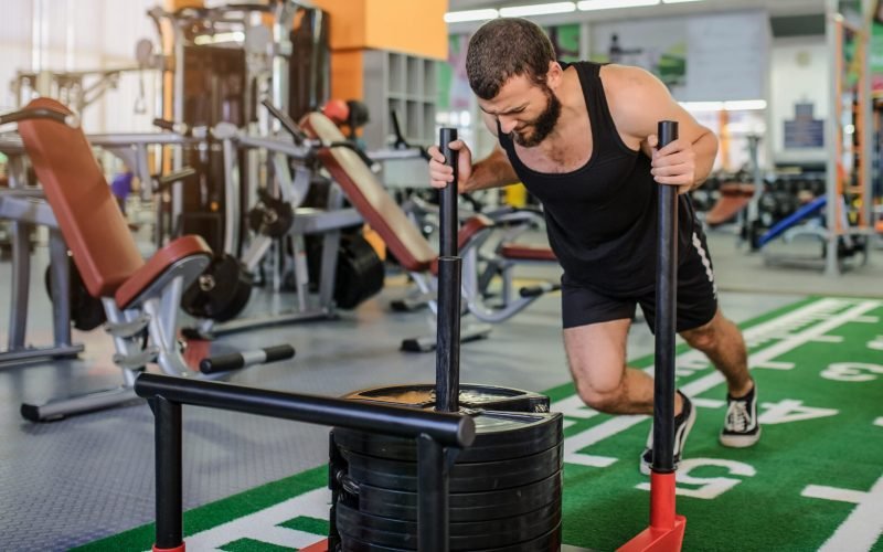 Lateral,View,Of,A,Man,With,Beard,Pushing,Weights,At